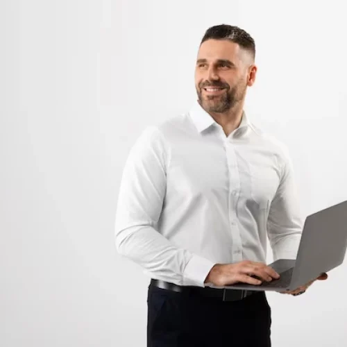 successful-middle-aged-man-formal-wear-using-laptop-grey-studio-background-looking-aside-free-space_116547-52139